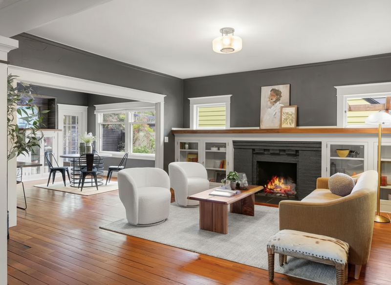 Pre-1940s Craftsman living room with built-in cabinets flanking fireplace, original fir floors, and columned room openings